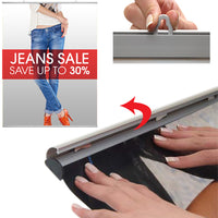 By hand, simply snap open both snap bar rails, top and bottom, slide graphic or poster in, and snap close 